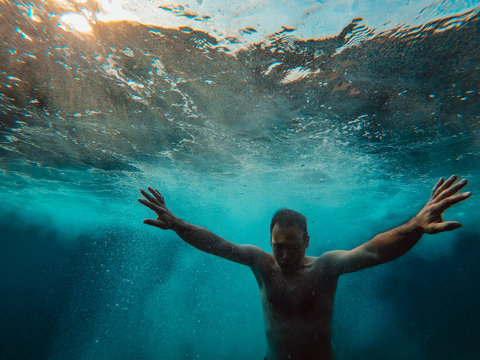 Underwater photo of man emerging from the water