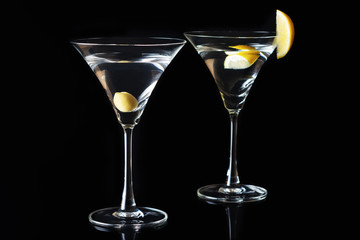 Martini Glasses with olive and lemon piece  on a black background. Selective focus.