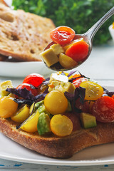 Bruschetta with avocado, tomatoes and  basil with balsam sauce. Close up. Selective focus.