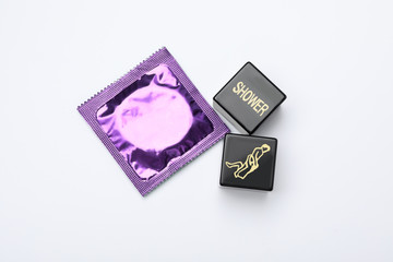 Sex dice and condom on white background, top view
