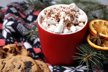 Cup of tasty cocoa with marshmallows on knitted cloth, closeup