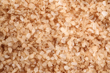 Brown sea salt as background, top view. Spa treatment