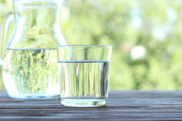 clear water in a glass on a table on nature. Purified water.