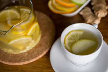 Hot lemon, ginger and apple tea with spices in a glass teapot. Health fresh fruit drink. Enjoying hot beverage in cold winter evening. Selective focus