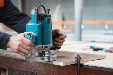 Furniture production or craft concept: worker polishing the wood surface of furniture part with...