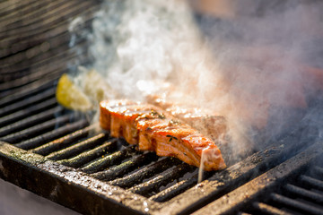 Grilled fish steaks. Pieces of salmon are fried over an open fire. Fire and smoke roll over pieces of fish