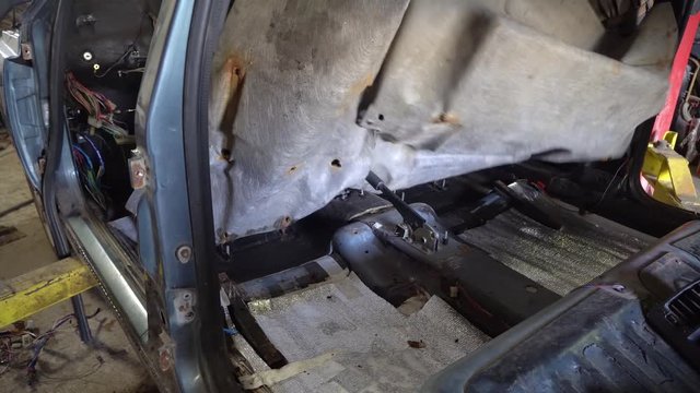 mechanic disassembles a car to replace noise insulation.