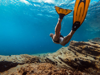 Underwater photo of men snorkeling by the sea reef