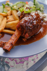 Lamb shank on a plate with salad