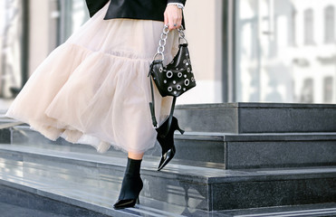 Fashionable bag close-up in female hands.Girl walks in the city outdoors. Stylish modern and...