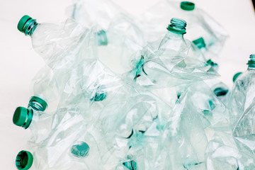 heap of empty crumpled plastic bottles on a white background