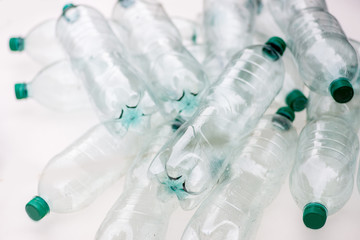 heap of empty crumpled plastic bottles on a white background