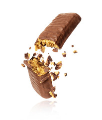 Chocolate bar with nougat crushed in the air on white background