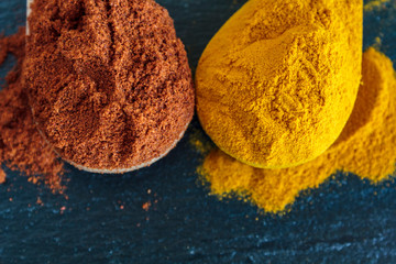 Close up of spoons with cayenne pepper and turmeric powder