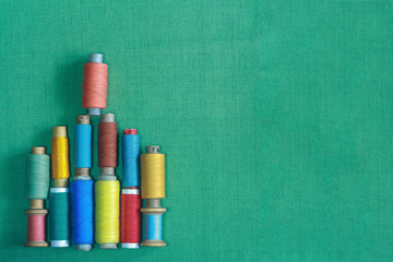 Row of colorful needlework coil threads, craft, sewing concept. Multicolored spools of thread on a...