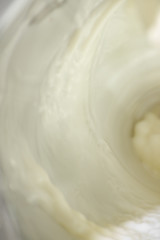 Fototapeta na wymiar Vertical background with flowing white milk, soft focus