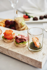 Buffet table with snacks, canape and appetizers at luxury wedding reception, copy space. Serving food and drinks at event. Catering banquet table