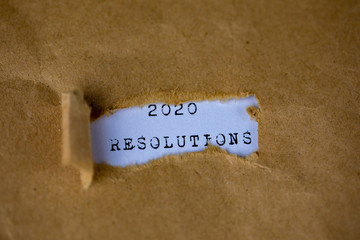 The text, 2020 resolutions , appears behind torn brown paper