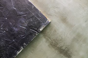 wooden background covered with putty on the background of cement-concrete wall