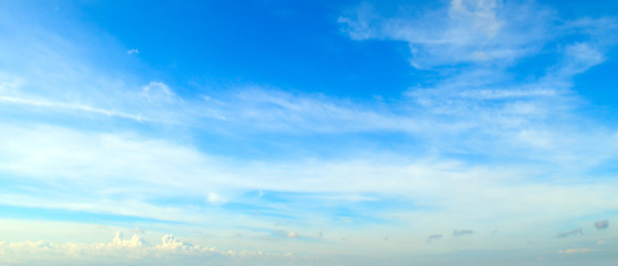 White fluffy clouds in blue sky. Wide photo.