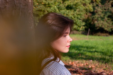 portrait of an attractive young woman, a girl who is enjoying the sunset on the street in the Park in the background.
