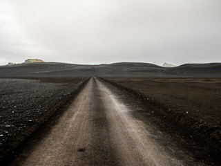 Dirt roadway running through interior Iceland on a raind day.