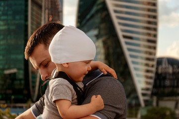 Father and one year old son against the sky and skyscrapers. Travel with children, the development of emotional intelligence. Early development.