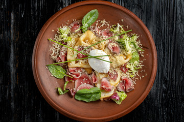 Diet menu. Salad with chopped steak, poached eggs, pancakes, green salad. Sprinkled with grated cheese.