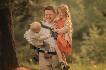 cheerful children hugging father in the park