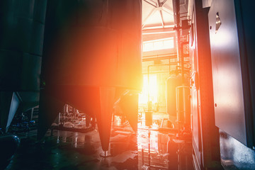 Drinking water factory production, industrial interior in sunlight. Large metal tanks for filtering and potable water treatment from well