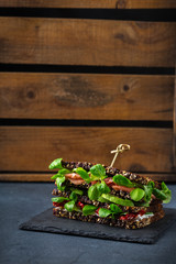 Fresh rye bread sandwich with ham, lettuce and tomato