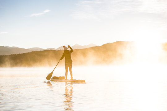 One woman paddle board on Lake Dillon in Summit County, Colorado in the early morning.         