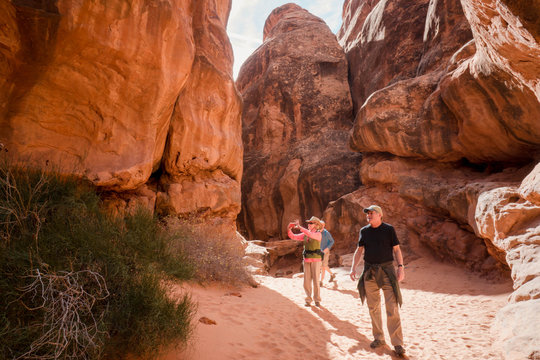 Active adult couple explores the Feiry Furnace in  Arches National Park outside of Moab, Utah.     