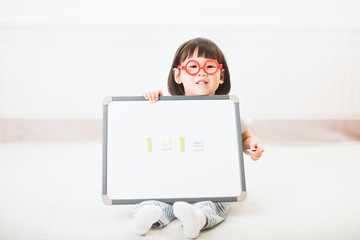 toddler girl using white board learning math  at home