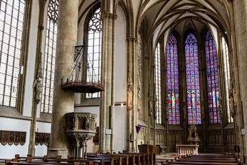 The interior of St Lambert's Church in Munster with a purple stain glass window