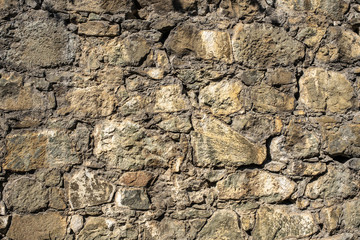 Stone structure of large and small stones in sunlight.