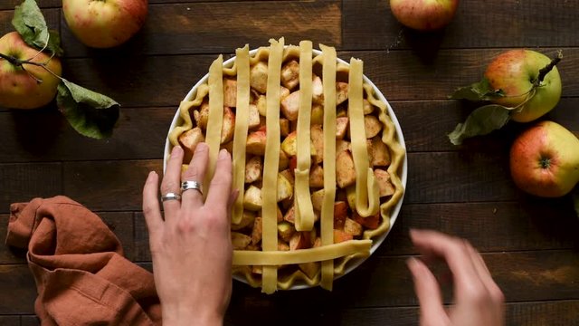Lattice apple pie cooking process, timelapse footage. Woman hands preparing food. Top view