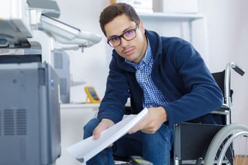 Fototapeta premium businessman in wheelchair using a printer