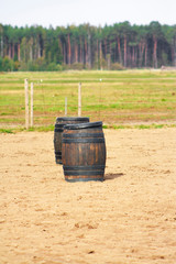 Obraz premium Two brown wooden barrels in the equestrian outdoor arena. Trail competition.
