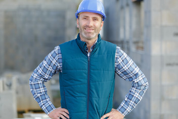 portrait of a builder in overalls and helmet