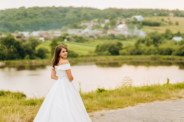 Fototapeta na wymiar Beautiful bride in white dress posing in the park