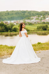 Fototapeta na wymiar Luxury bride in white dress posing in the park