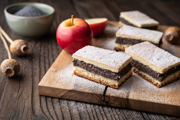Delicious pie made from leavened dough with poppy seed and apple filling, sprinkled with powdered sugar