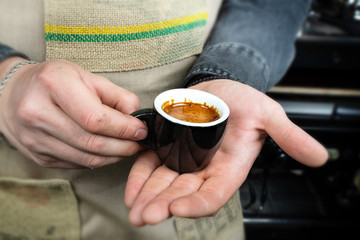 Barista makes espresso coffee in cafe closeup