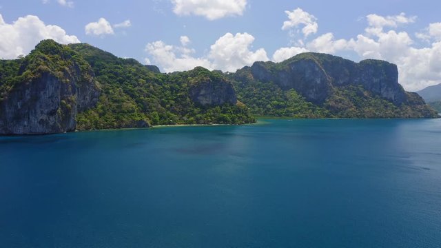 Aerial approaching fly towards Lagen island. El Nido, Palawan, Philippines. Deep blue ocean water of Bacuit bay
