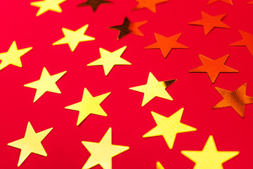 Bunch of gold stars on red background.