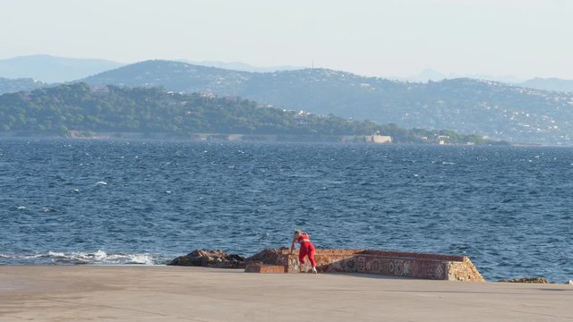 Healthy woman doing exercices in front of the sea red legging attractive blonde girl