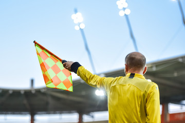 Sideline soccer fereree raise the flag up.
