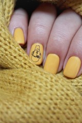 Stylish trendy female manicure. Neon yellow nails on yellow  background. Nail polish. Art manicure. Modern style.