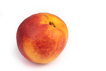 on a white background, highlighted in close-up, lies a ripe, fleshy red-yellow nectarine. fresh, unexpectedly plucked from a tree